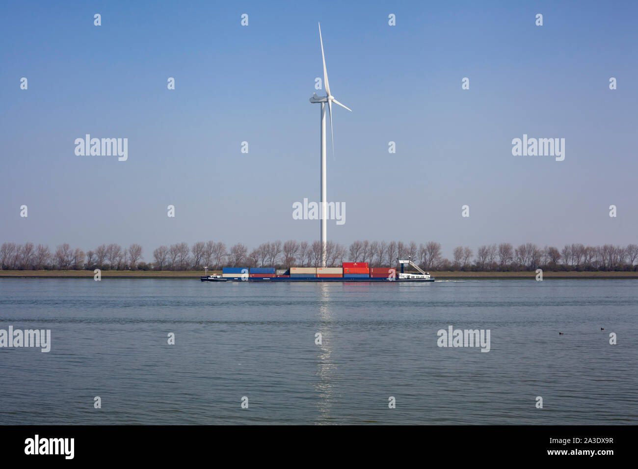 Netherlands, New Waterway. Container ship in front of modern windmill shipping, transport and heavy industry nera Maasvlakte 2. Stock Photo