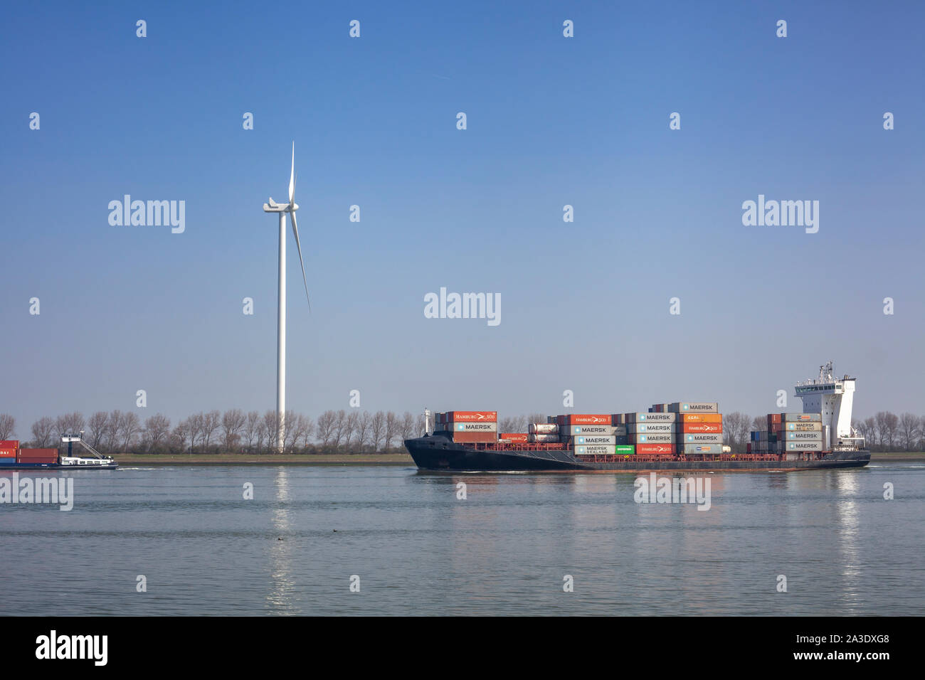 Netherlands, New Waterway. Container ship in front of modern windmill shipping, transport and heavy industry nera Maasvlakte 2. Stock Photo