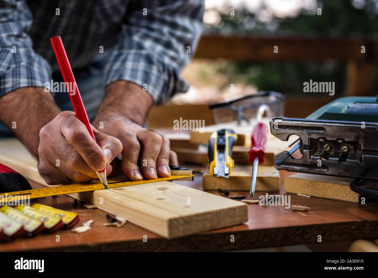 Adult carpenter craftsman with a pencil and the carpenter's square