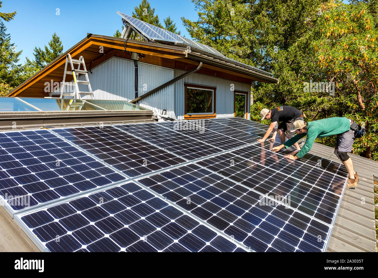 Workers install solar photovoltaic panels on a homeowners roof in