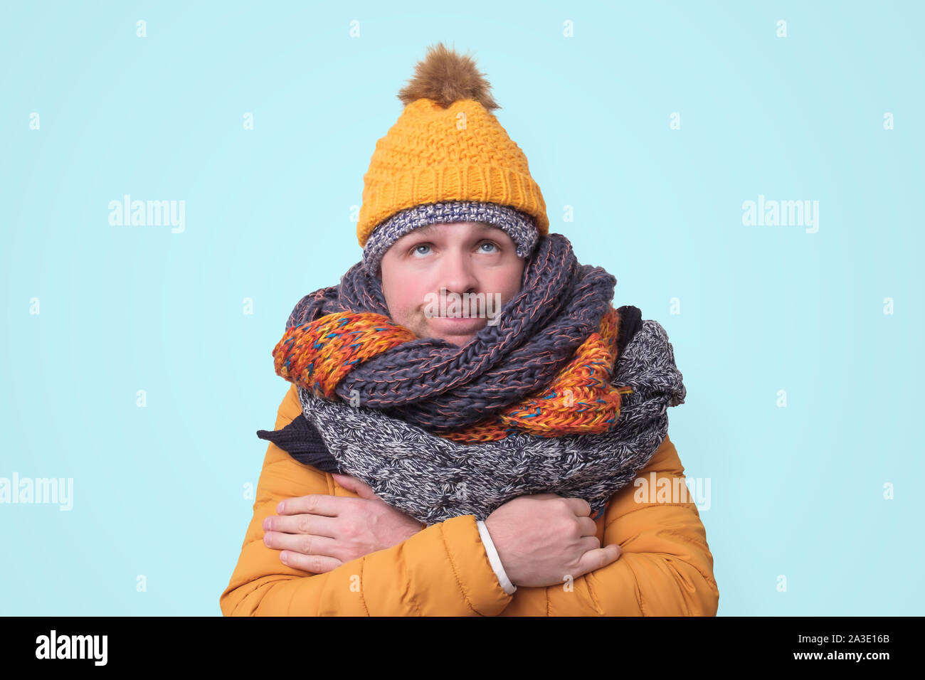 Handsome caucasian funny man in several hats and scarfs. Stock Photo