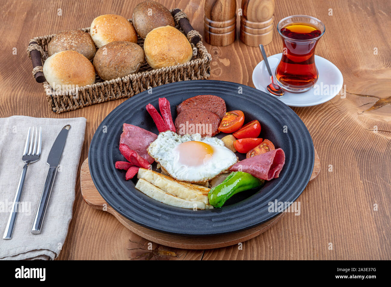Delicious hot breakfast platter; Sausage, salami, pepper, tomato, fried hellim cheese. Restorant breakfast concept on wooden table. Stock Photo