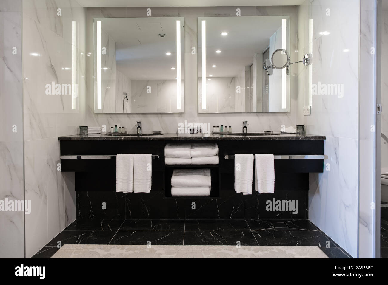 Modern twin bathroom with sinks, mirrors and towels Stock Photo
