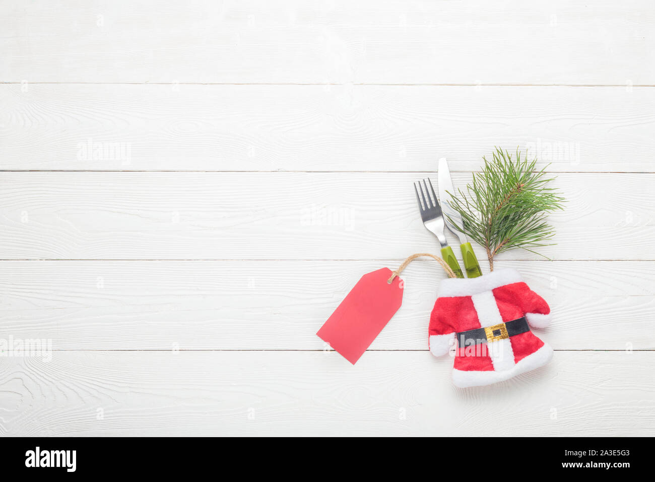 Christmas fork, knife with price tag on white wooden background Stock Photo
