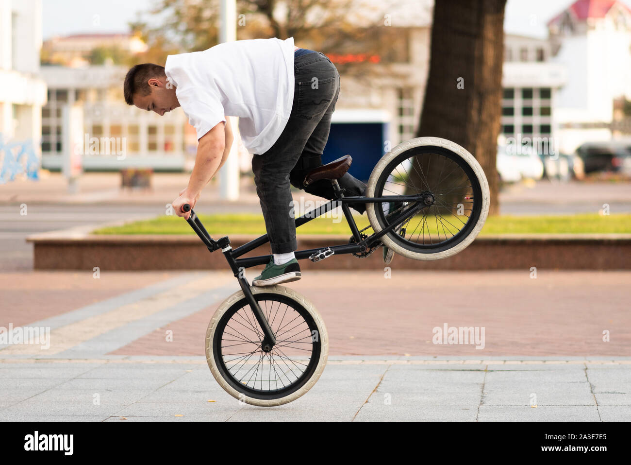 The guy on the BMX bike performs a trick on the front wheel Stock Photo -  Alamy
