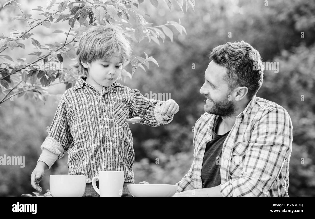 Little boy and dad eat. Organic nutrition. Healthy nutrition concept. Nutrition habits. Family enjoy homemade meal. Personal example. Nutrition kids and adults. Father teach son eat natural food. Stock Photo