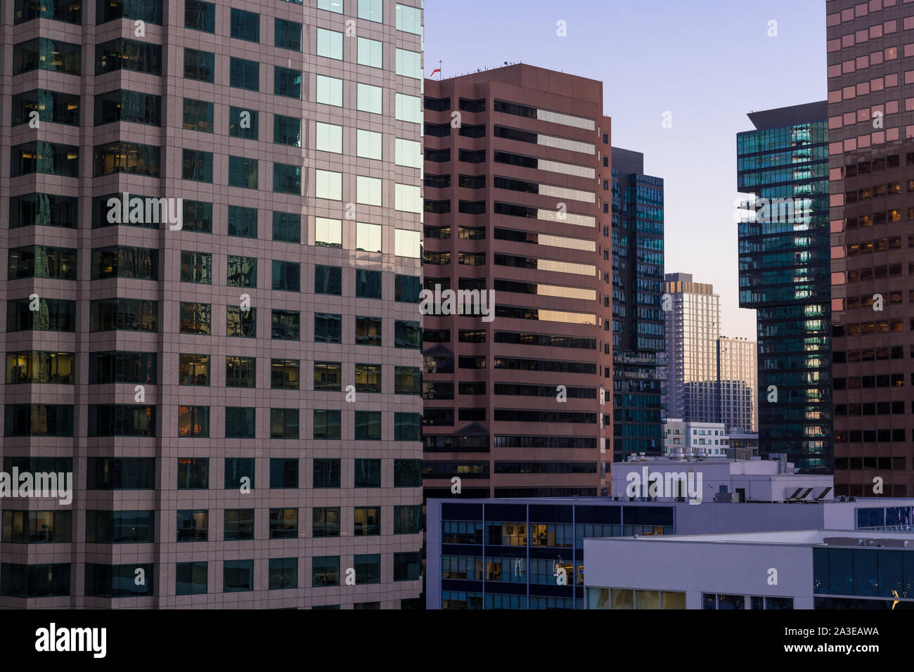 Urban scene of modern glass, steel and concrete buildings at sunset in