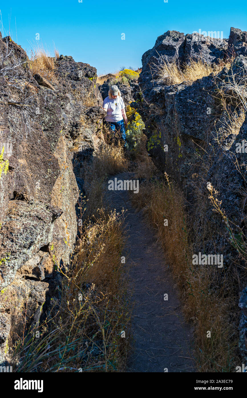 California, Lava Beds National Monument, Captain Jack's Stronghold, female visitor on trail Stock Photo