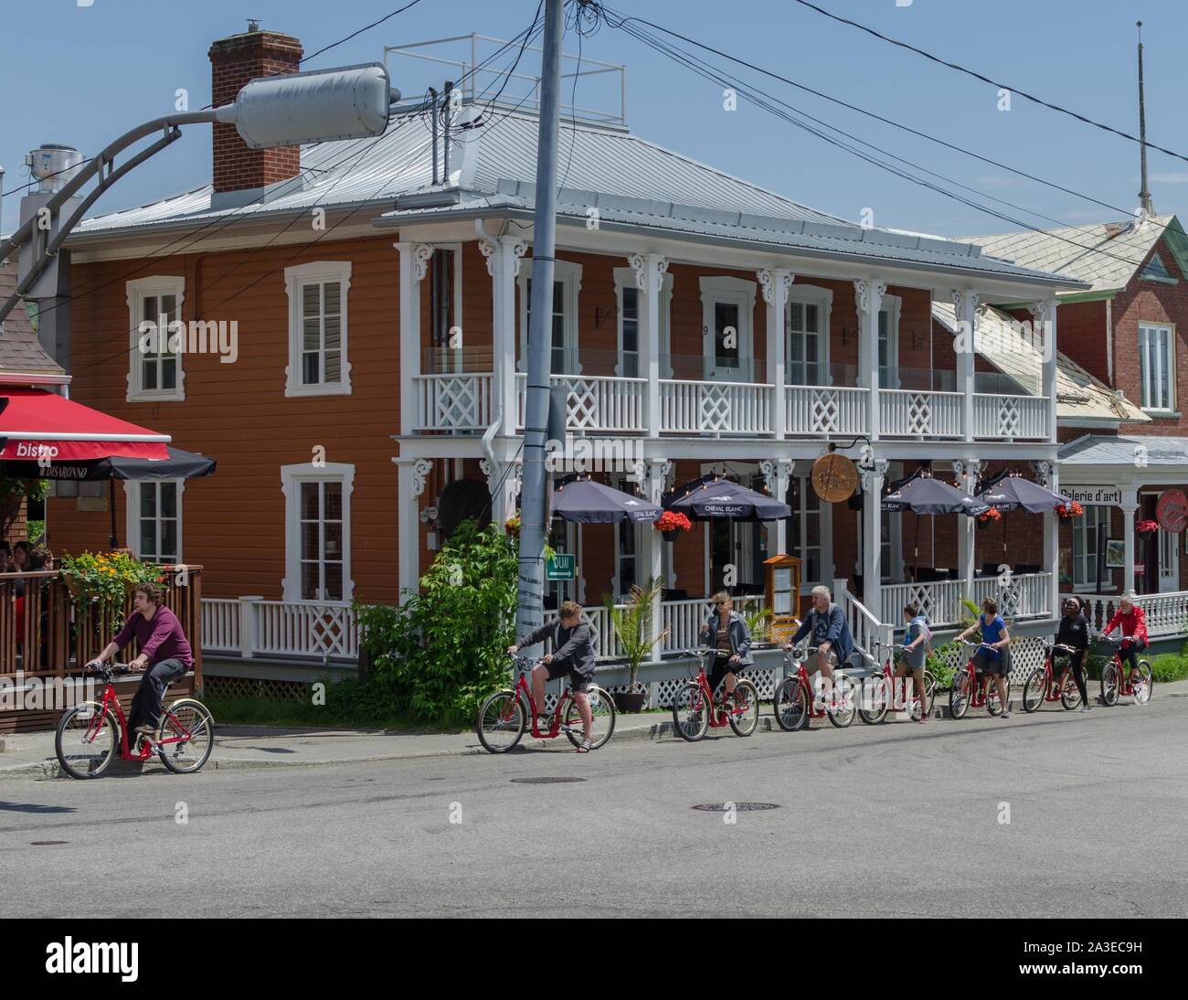A group of tourists on bicycles stop outside one of the many alfresco restaurants in Baie Saint Paul, Quebec. Stock Photo