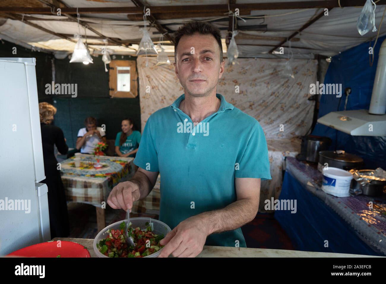 A man poses in his falafal restaurant in Camp Ritsona.  The man had asked his mother for the recipe and kept it as a closely guarded secret, refusing to share it with anyone on the camp.  In 2018, there were almost 66,969 official applications for asylum according to the statistical data published by the Asylum service.  The UNHCR cites 15,670 as the number of refugees who have arrived in 2019. Stock Photo