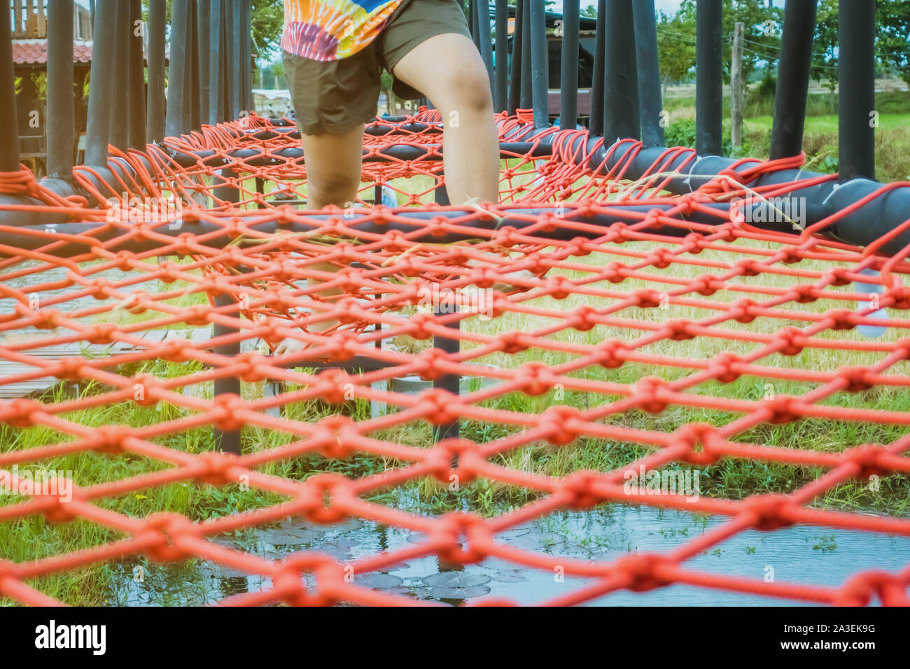 Swampy Rope Young woman tried to walk on the bridge floor tied with a red rope to ...