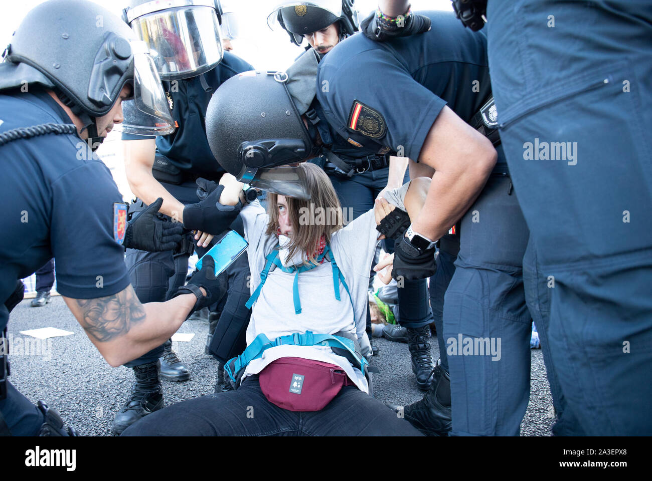 Police officers arrest an activist during the protest.Cities worldwide like London, Berlin, New York, Buenos Aires, París started the second international week rebellion while activists perform in different actions of pacific protests and civil disobedience under the ethical duty to reclaim responsibility a political action for the purpose of mitigate the serious consequences of climate change and ecological impact. In Madrid they were two parallel actions, one in “Paseo de la Castellana”, where a main road was blocked for a human chain and there were some activists who were arrested and the s Stock Photo