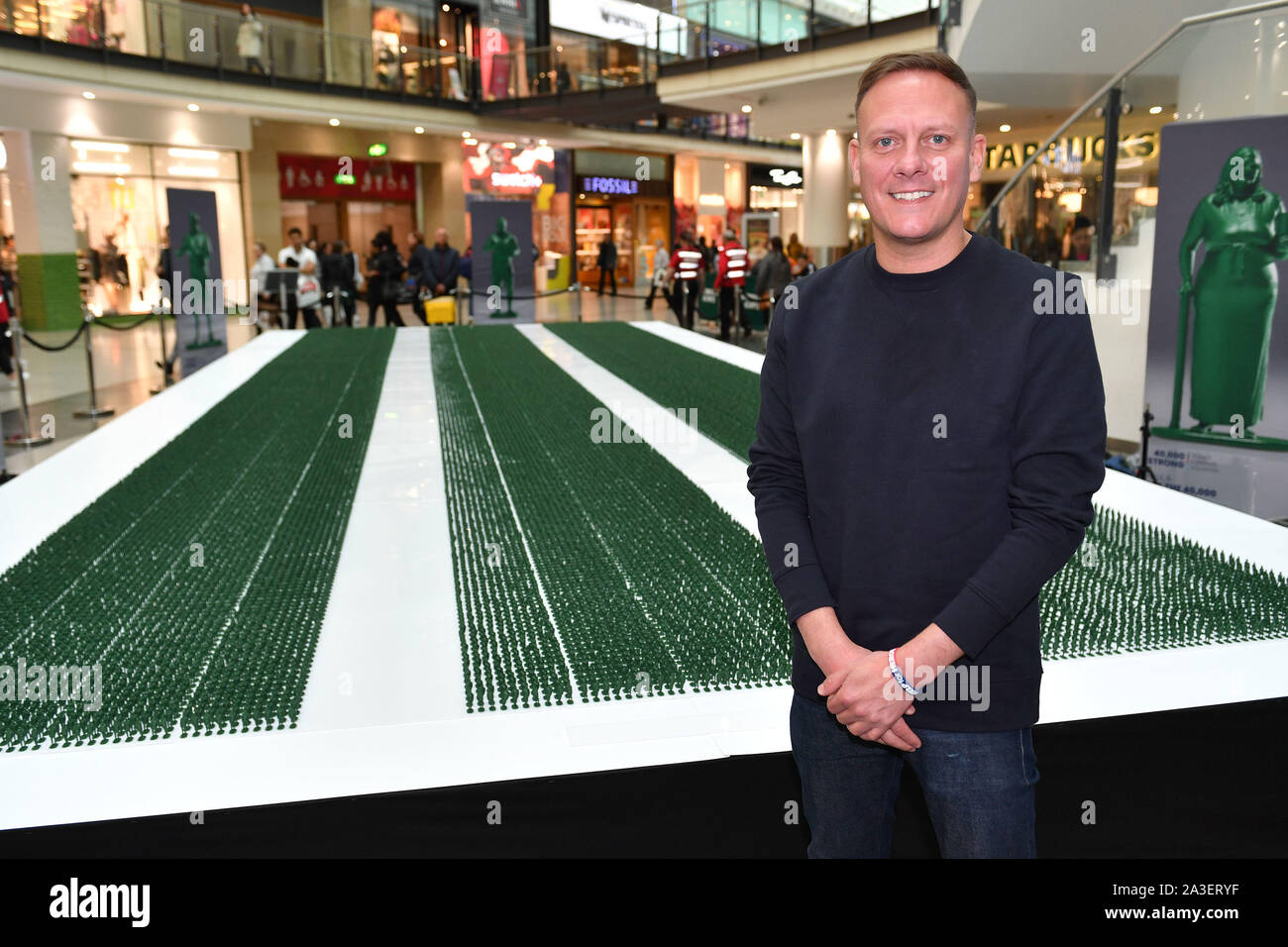 Actor Antony Cotton poses beside a model force of 40 000 military