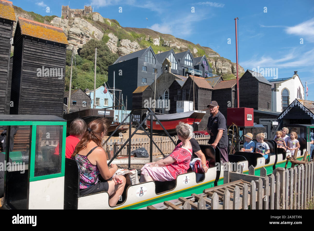 Hastings miniature railway train leaving Rock-a-Nore station by the net huts in the Old Town, East Sussex, UK Stock Photo