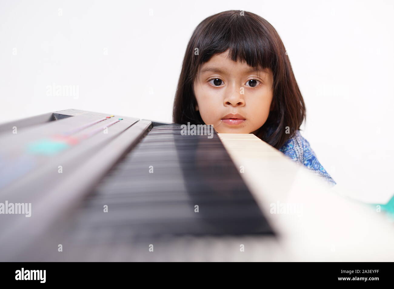 Happy little girl playing electric piano Stock Photo - Alamy