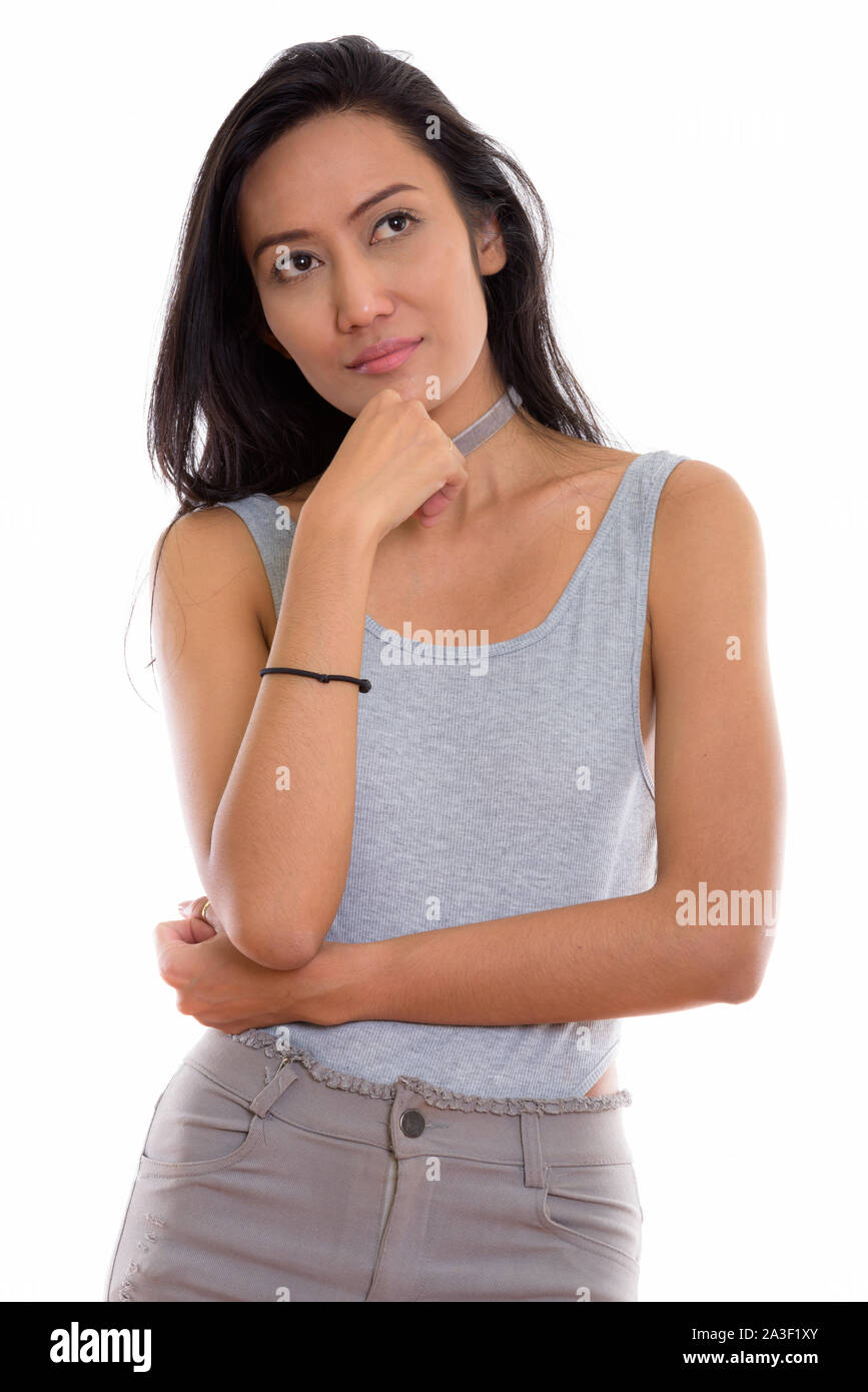 Studio shot of young beautiful Asian woman thinking while lookin Stock ...