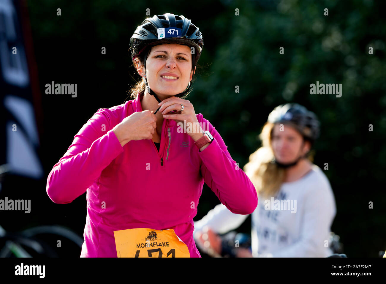A triathlete removing her cycling helmet, Warwickshire Triathlon, UK Stock Photo