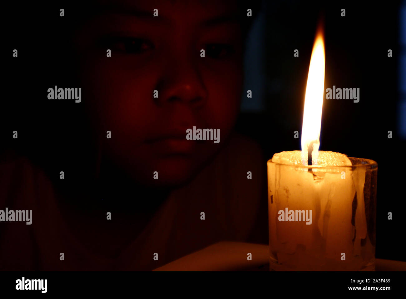 Photo of young child looking at candle Stock Photo