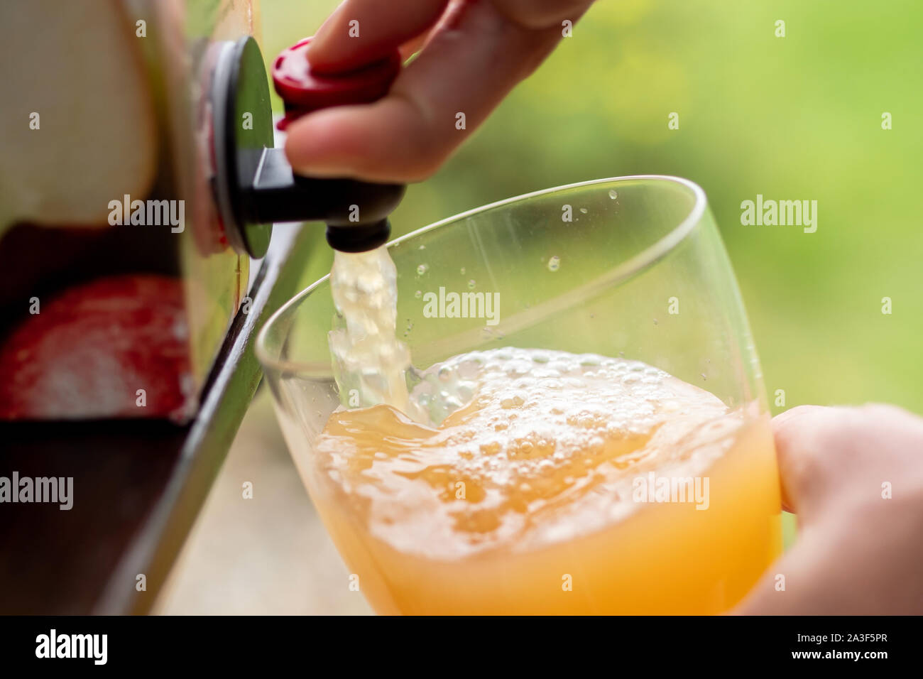 Vacuum boxed apple juice being poured into a glass. Stock Photo