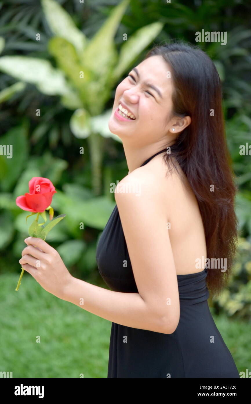 An Adult Female Laughing With Flowers Stock Photo