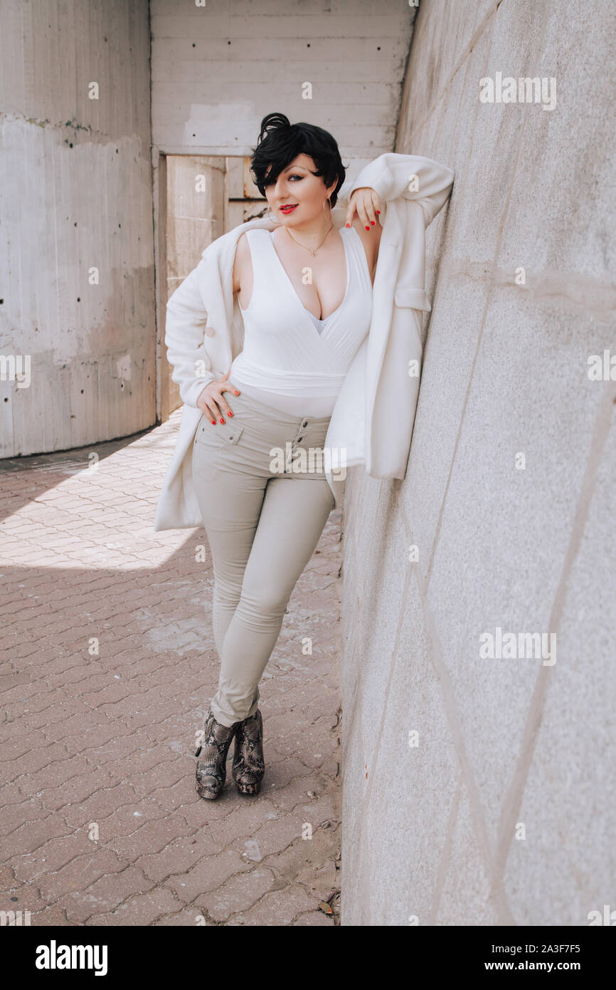 Young Beautiful Stylish Woman In White Wool Coat Walking Down The