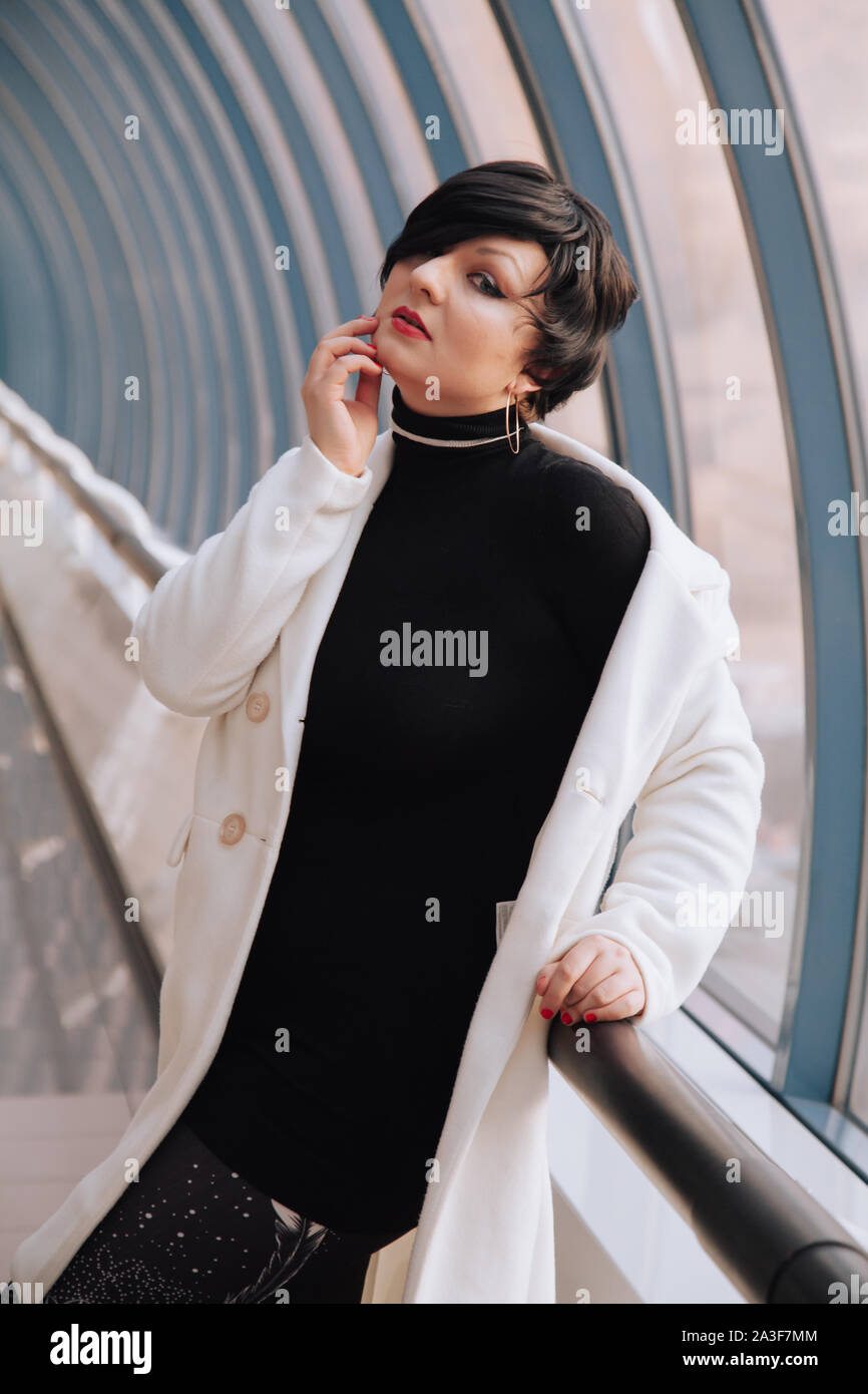 Young Beautiful Stylish Woman In White Wool Coat Walking Down The