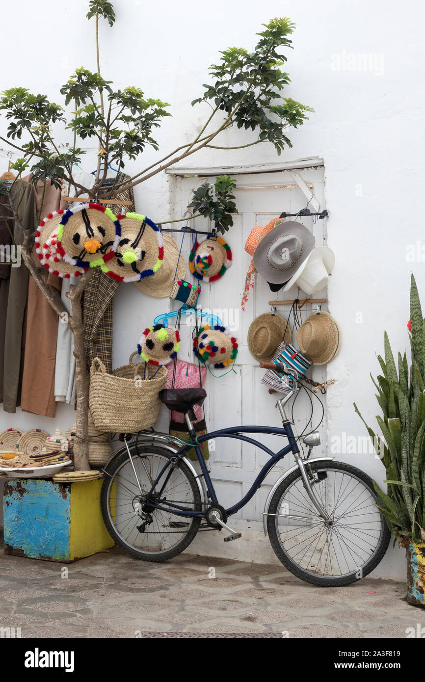 Bicycle standing in front of merchandise in the medina of Asilah, Northern Morocco Stock Photo