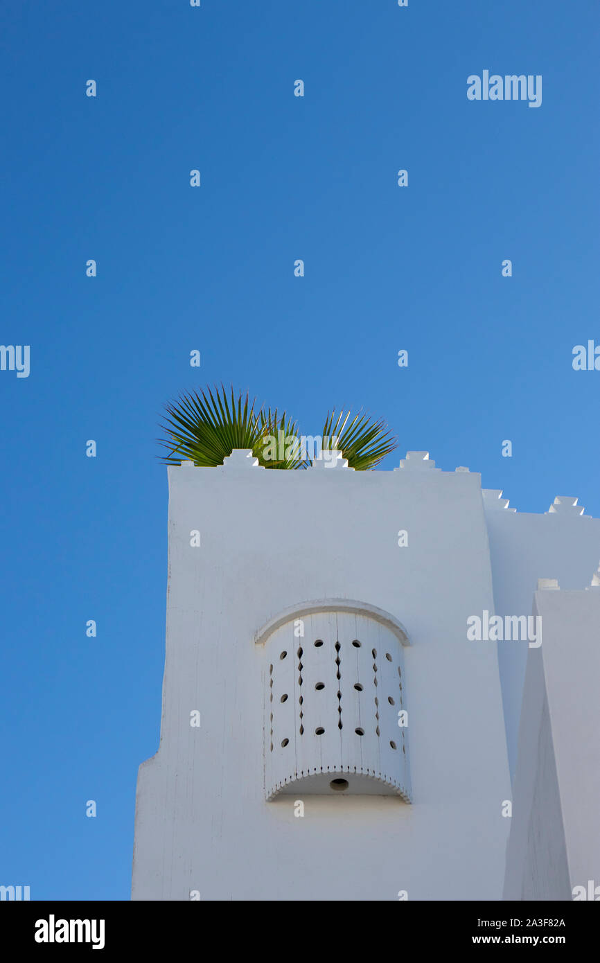 Moroccan white design window upstairs at a plasterd wall in Assilah, Morocco Stock Photo