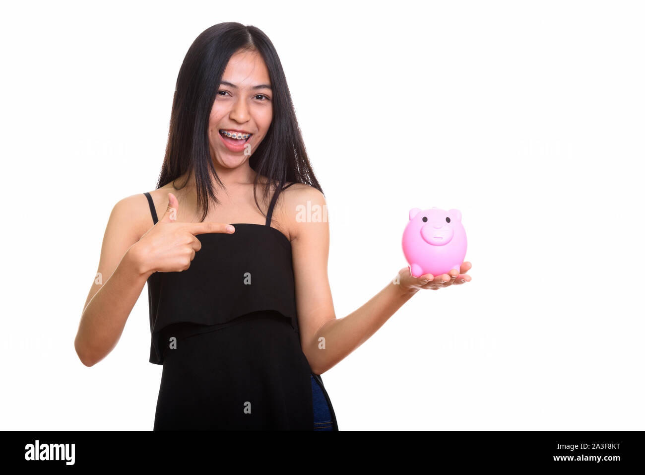 Young happy Asian teenage girl smiling while holding piggy bank Stock ...