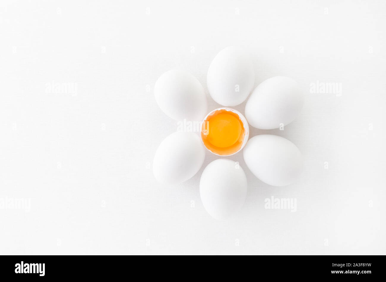 fresh white eggs with yolk on white background, flat lay Stock Photo