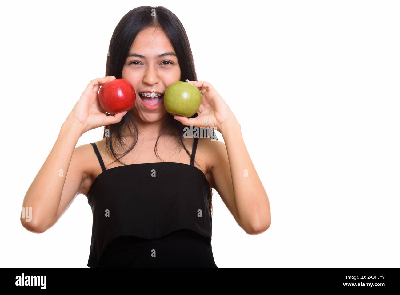 Young happy Asian teenage girl smiling while putting red and gre Stock ...