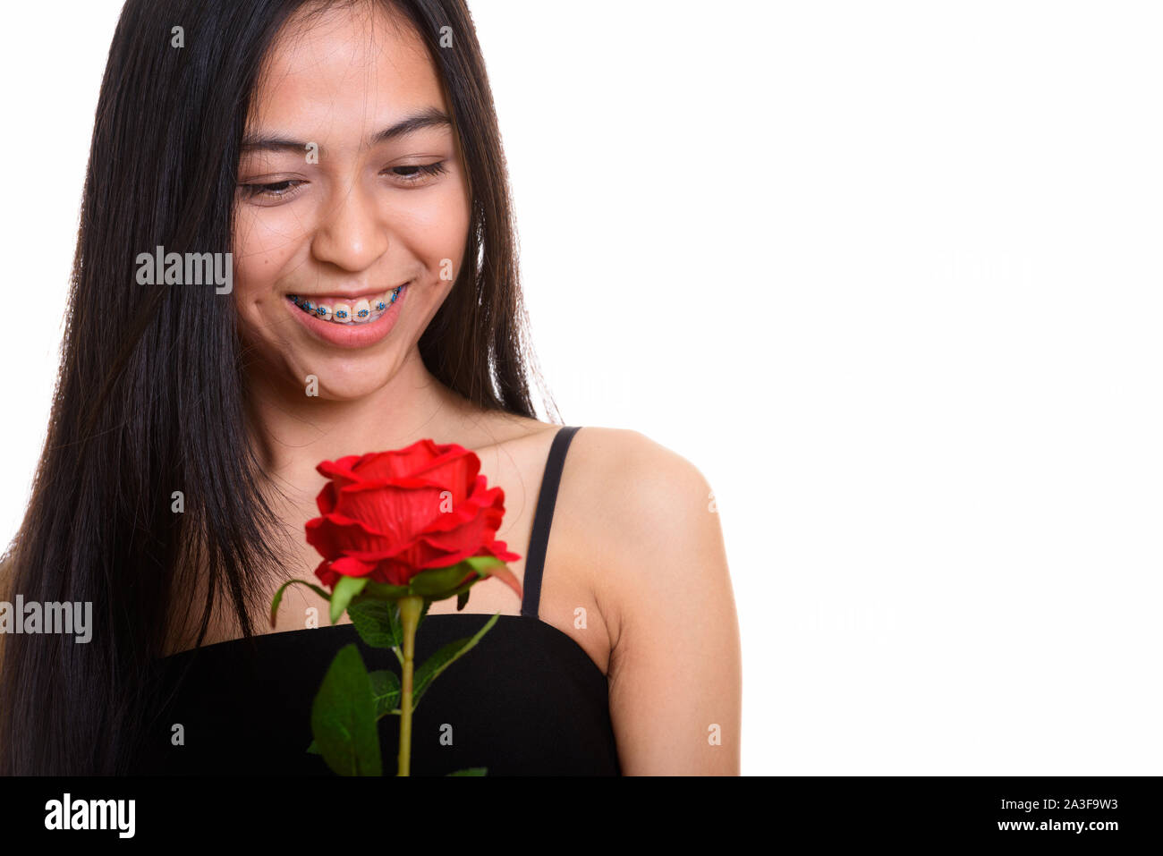 Young happy Asian teenage girl smiling while holding red rose Stock ...