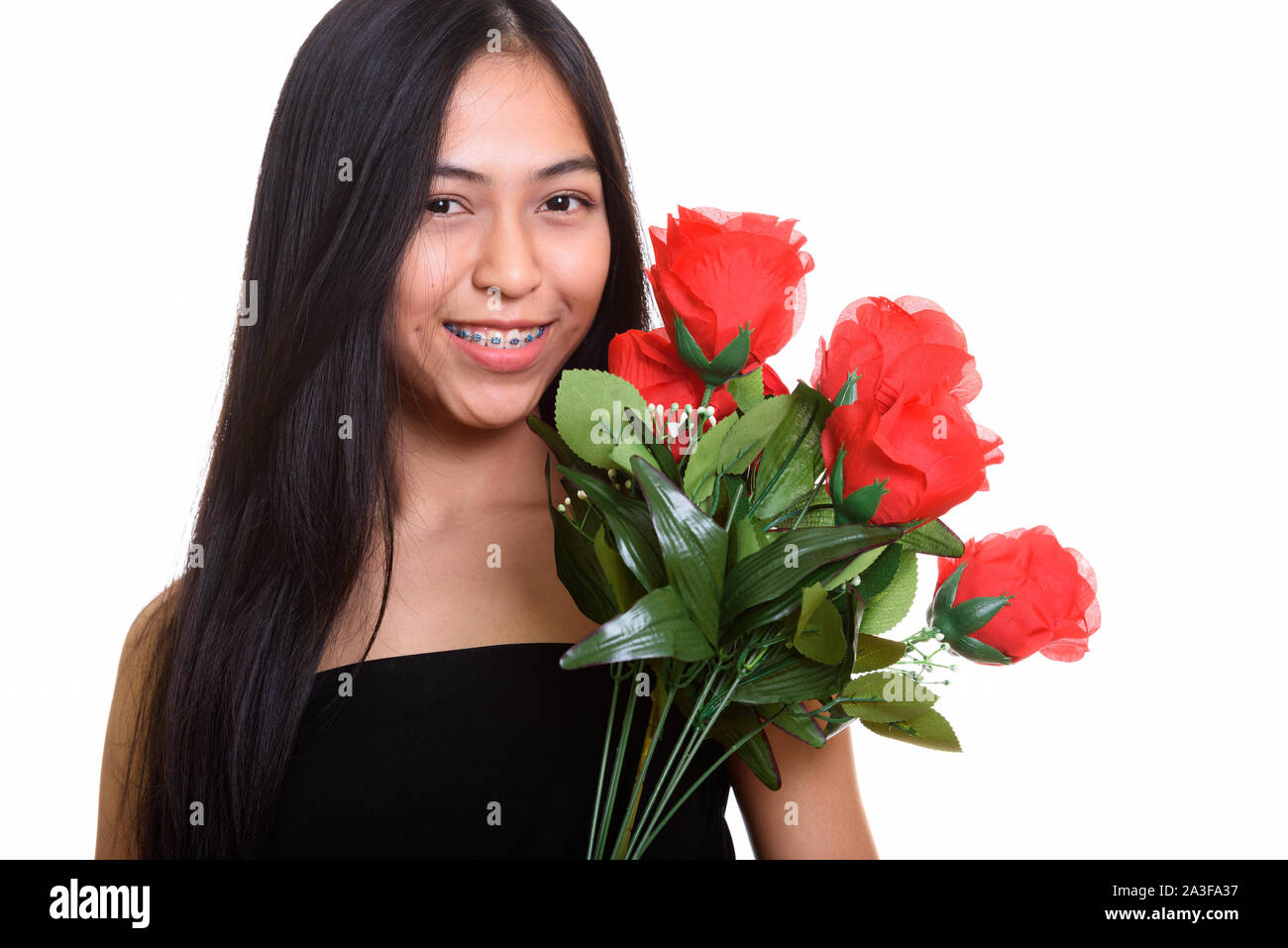 Young happy Asian teenage girl smiling while holding red roses Stock ...