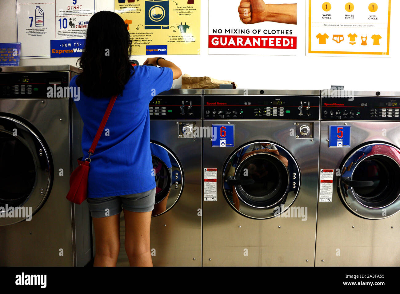 ANTIPOLO CITY, PHILIPPINES – OCTOBER 4, 2019: Customer puts dirty clothes  inside washing machine at self service laundry shop or laundromat Stock  Photo - Alamy