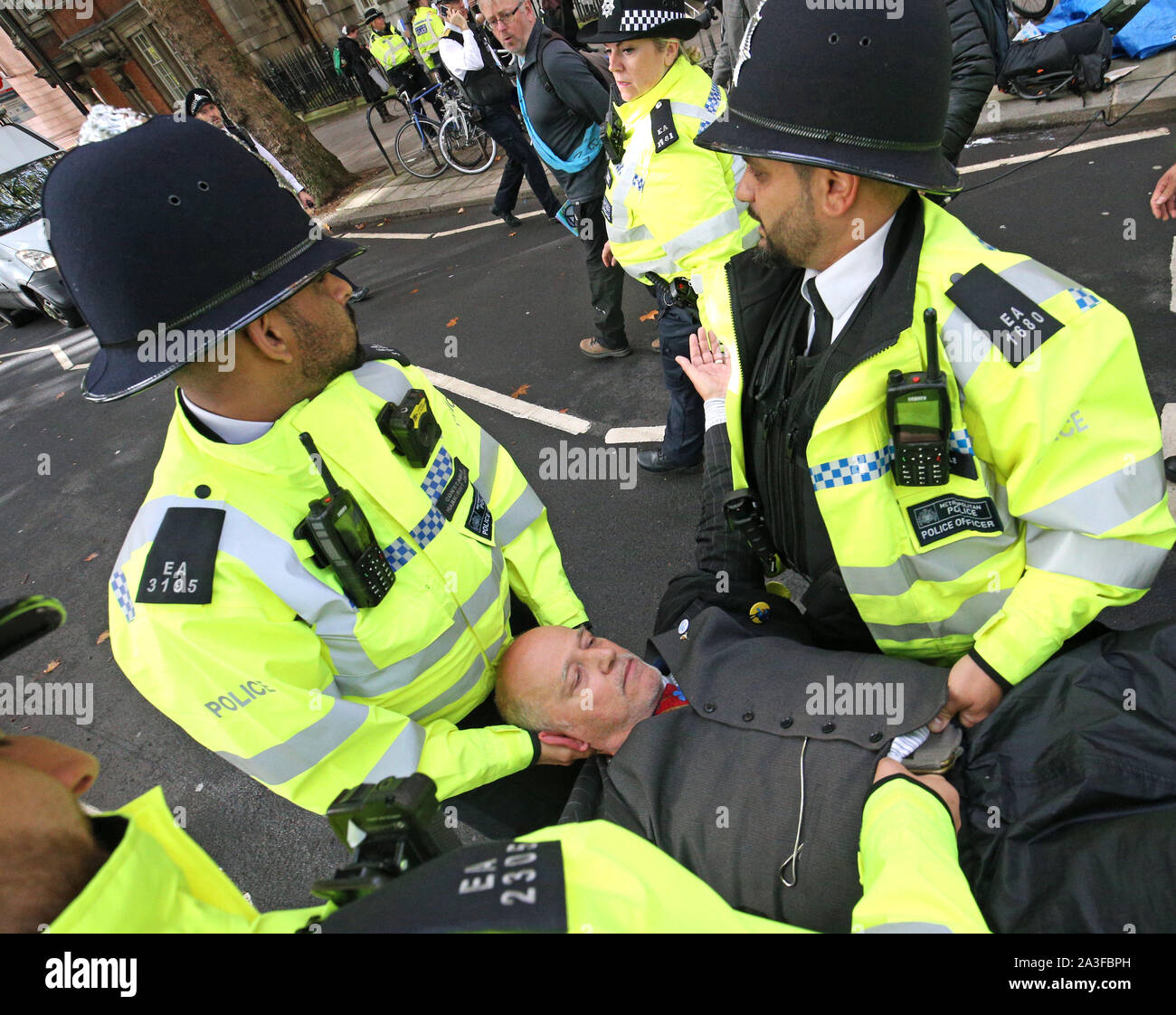 Police remove a prrotester at Millbank near to the junction with Great College Street, during an Extinction Rebellion (XR) protest in Westminster, London. Stock Photo