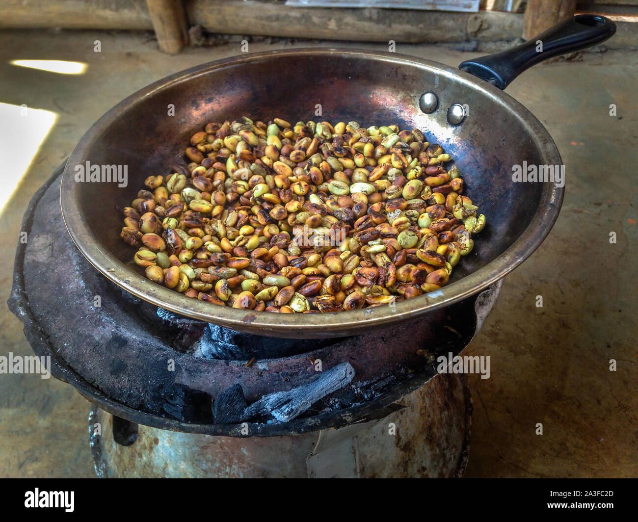 Traditional roasting of coffee beans with pan and charcoal in Ethiopia