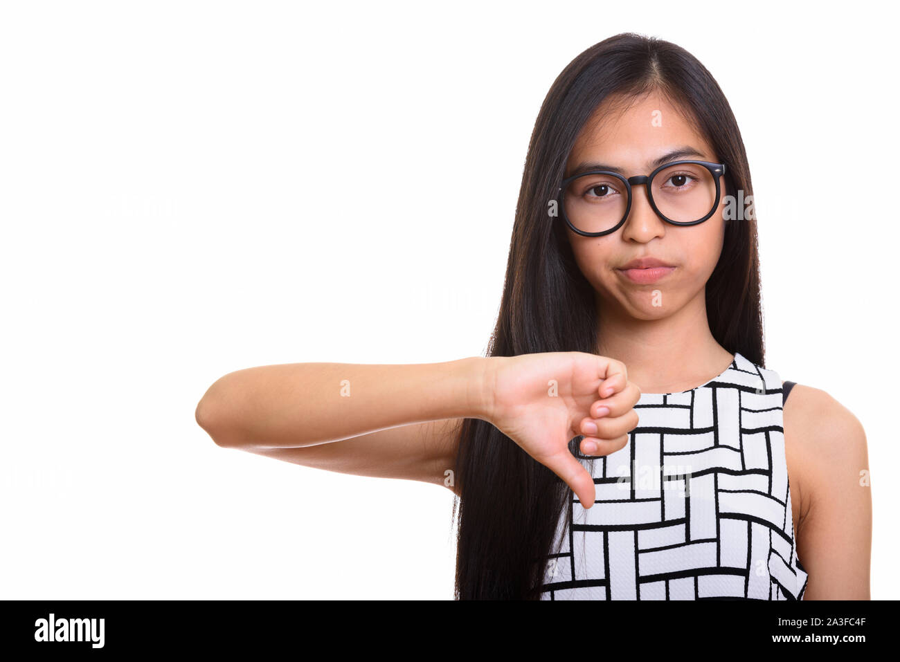 Young Asian teenage nerd girl giving thumb down Stock Photo