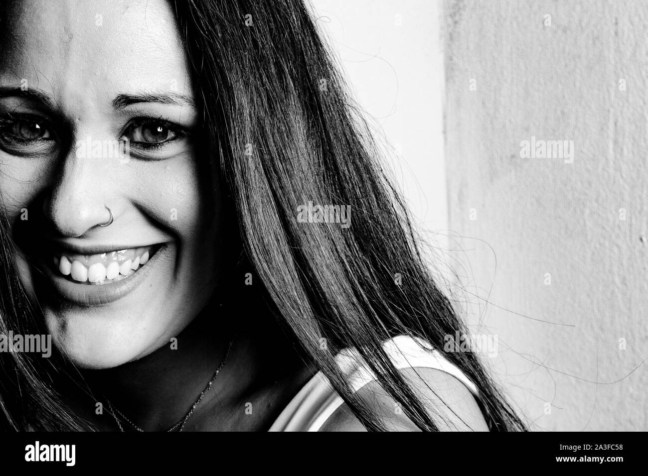 studio lighting portrait of a young woman smiling with expressive eyes Stock Photo