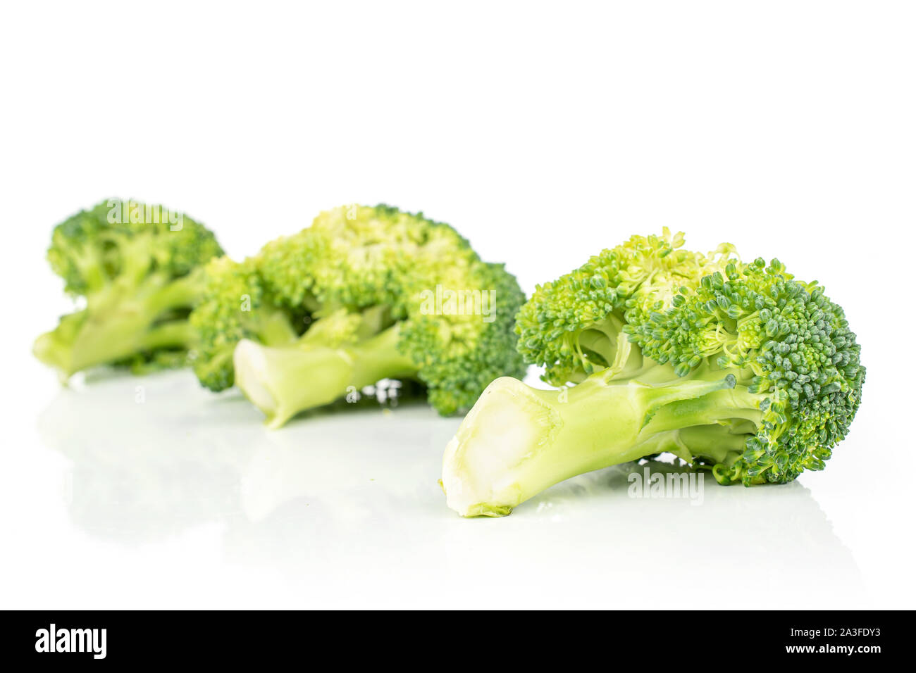 Group of three whole fresh green broccoli in diagonal isolated on white ...