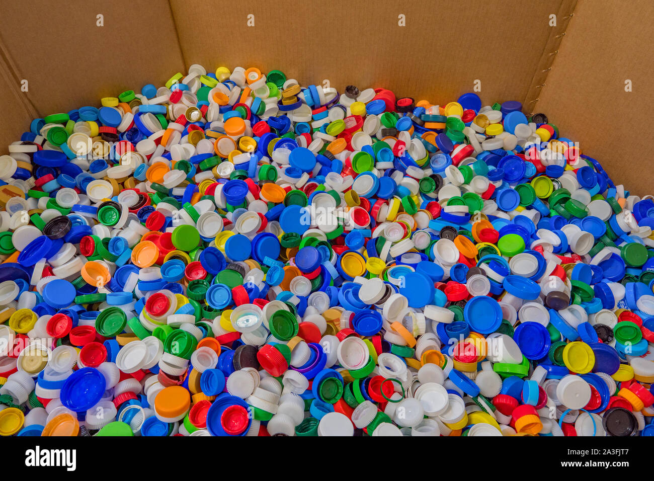 Plastic recycle. Sorting garbage. Waste recycling. Waste recycling plant. Colorful plastic bottle caps background. Colorful background of bottle caps. Recyclable waste concept. Material for processing Stock Photo