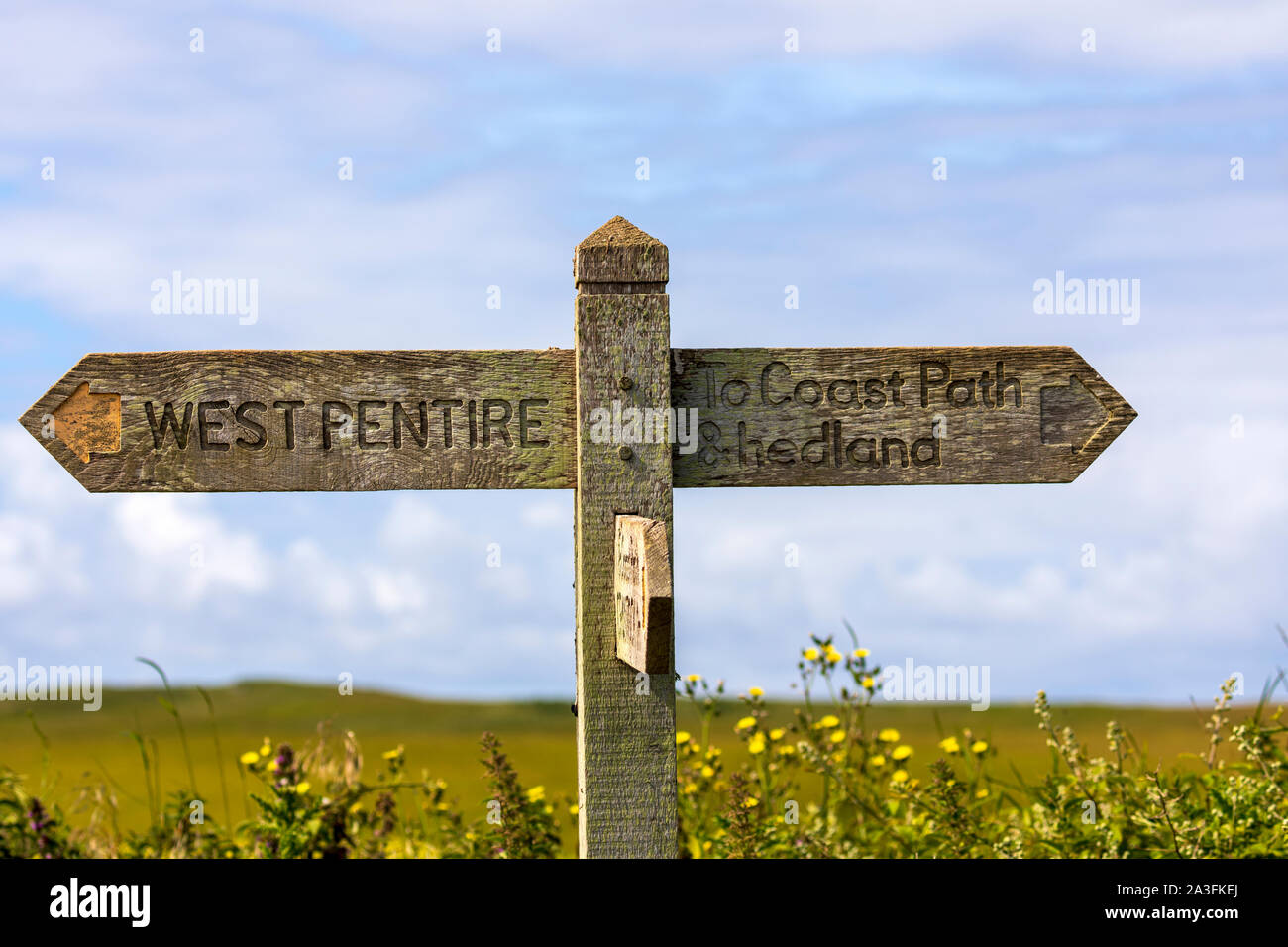 A Coastal path walking oak walking sign showing directions to West Pentire and To Coast Path Headland near Crantock Bay, Cornwall, UK Stock Photo