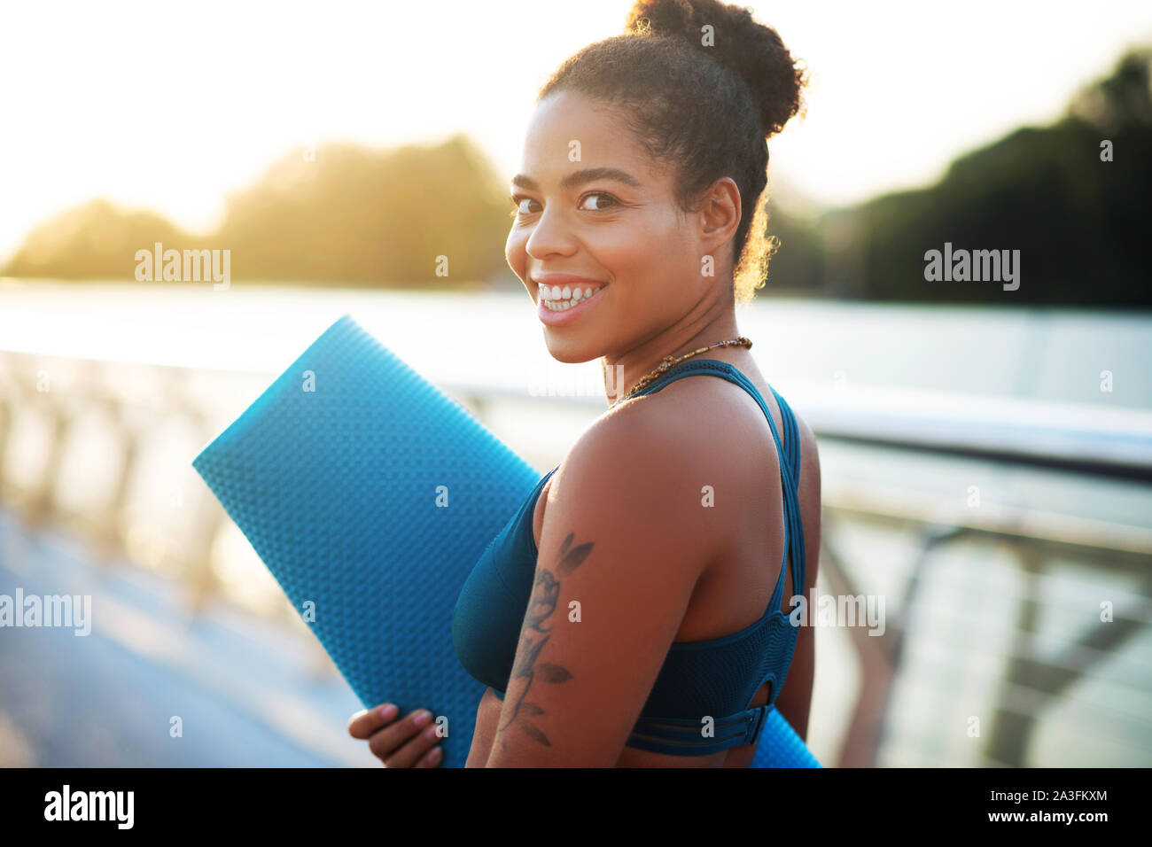 Dark-eyed woman showing toothy smile while going to workout Stock Photo
