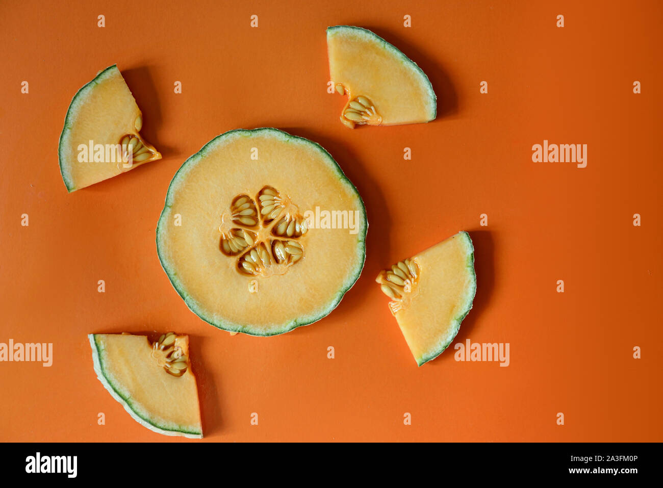 Slices cantaloupe sliced isolated on orange backgroundlices cantaloupe sliced isolated on orange background Stock Photo