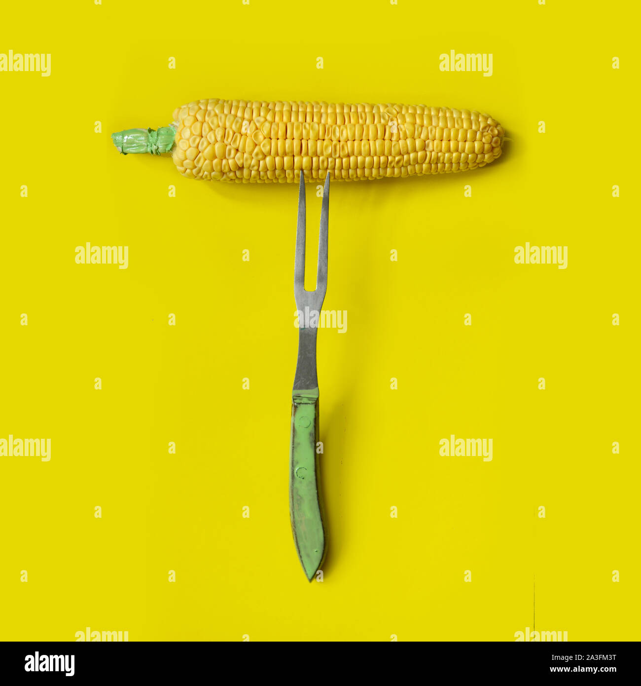 Corn on fork on yellow background. Minimal flat lay concept.blogger food concept Stock Photo