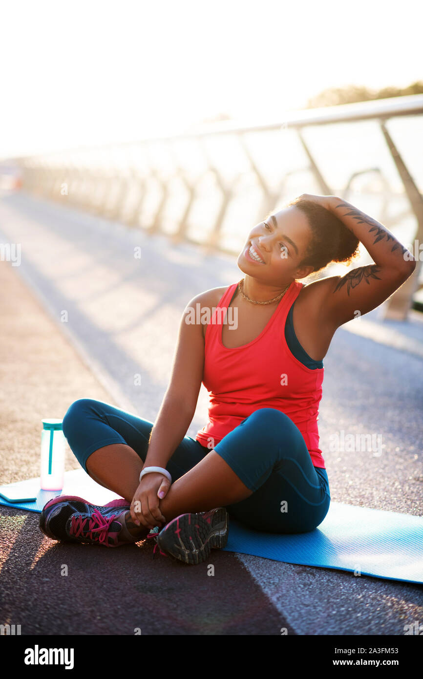Dark-skinned woman stretching neck while doing yoga Stock Photo - Alamy