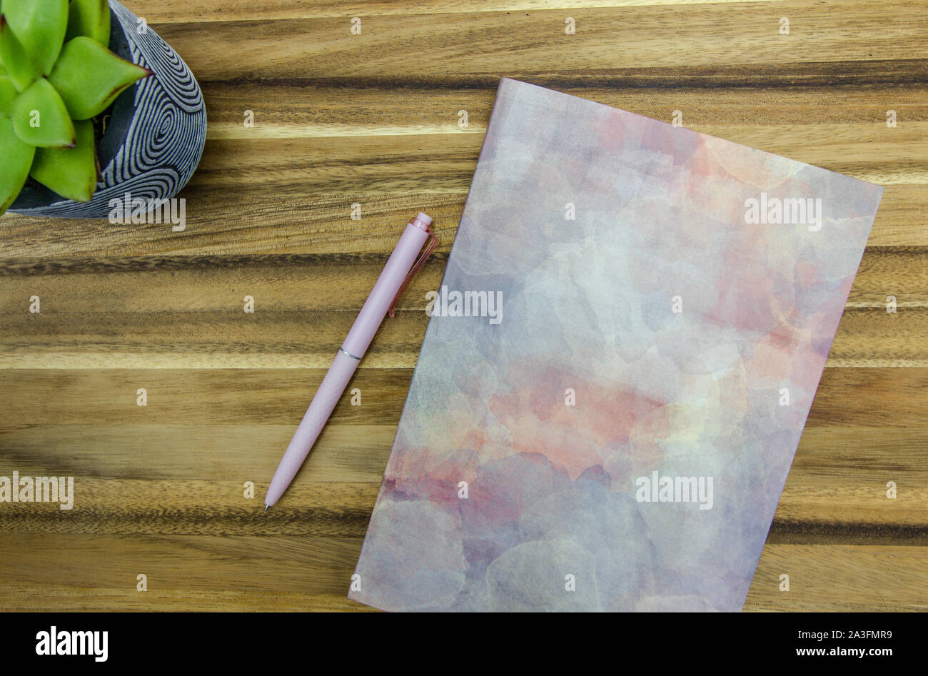 Top View of Stylish Notepad and Pen Next to Plant on Wooden Table Stock Photo
