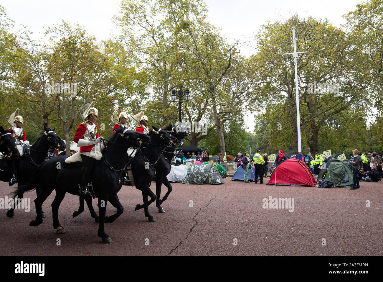 The household cavalry ride past Extinction Rebellion (XR) protester in central London. Stock Photo