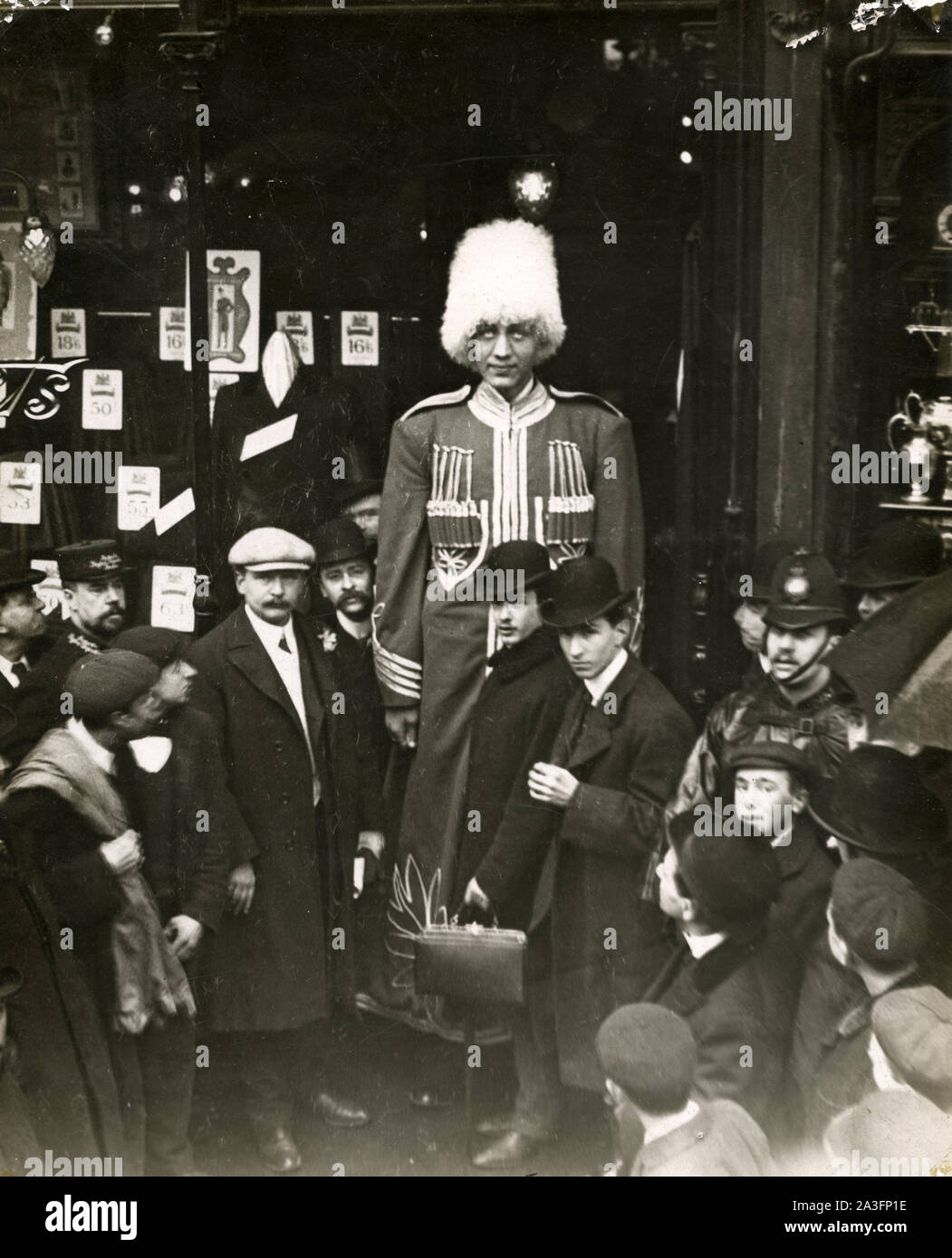 Ivan Markoff, who was famous as a Russian cossack giant in the early 20th  century. Markoff is seen in London where the caption says he was being  fitted for a new suit.
