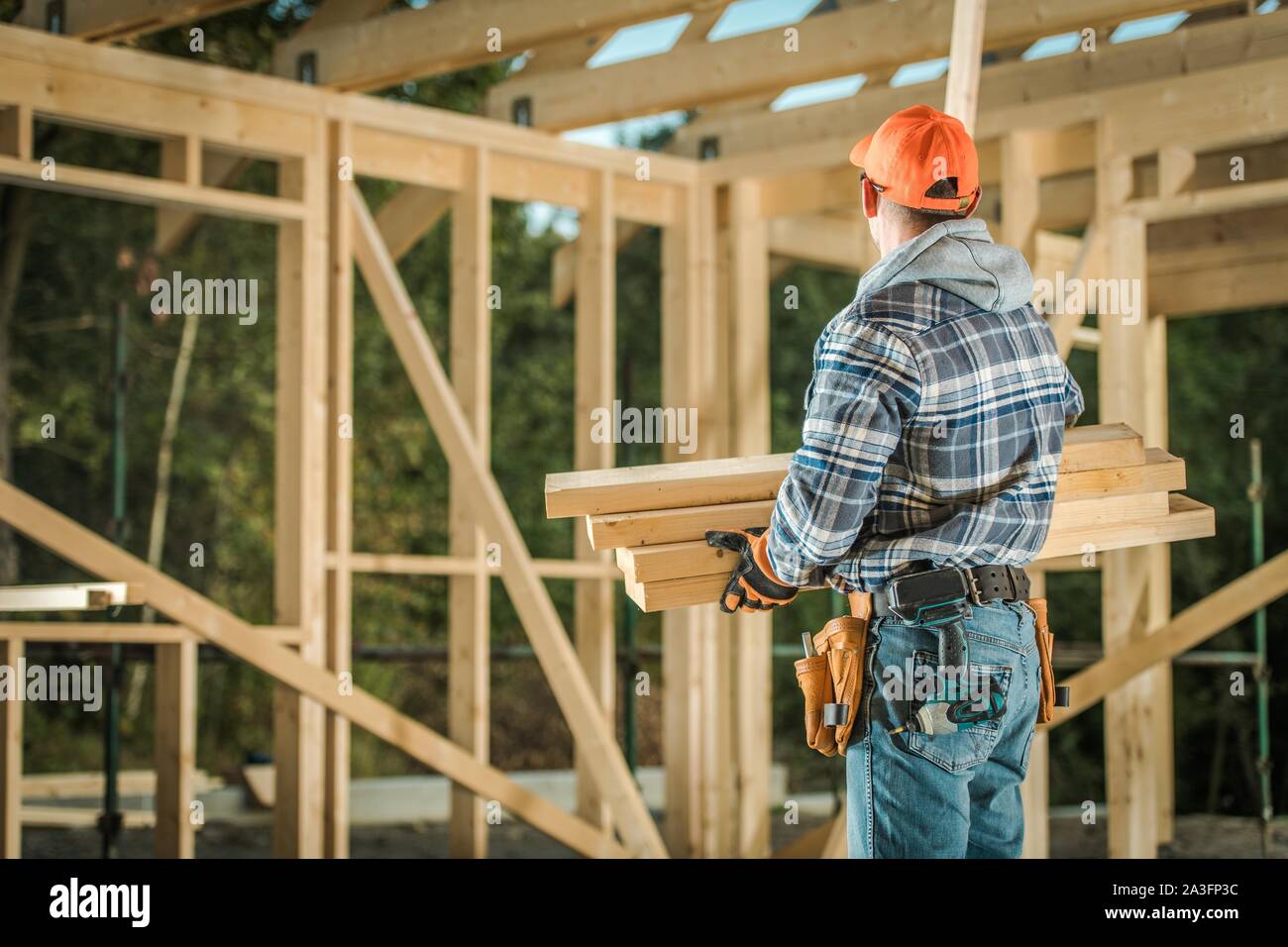 Caucasian Professional Carpenter with Wood Elements. Residential Building Wooden Frame Construction. Stock Photo