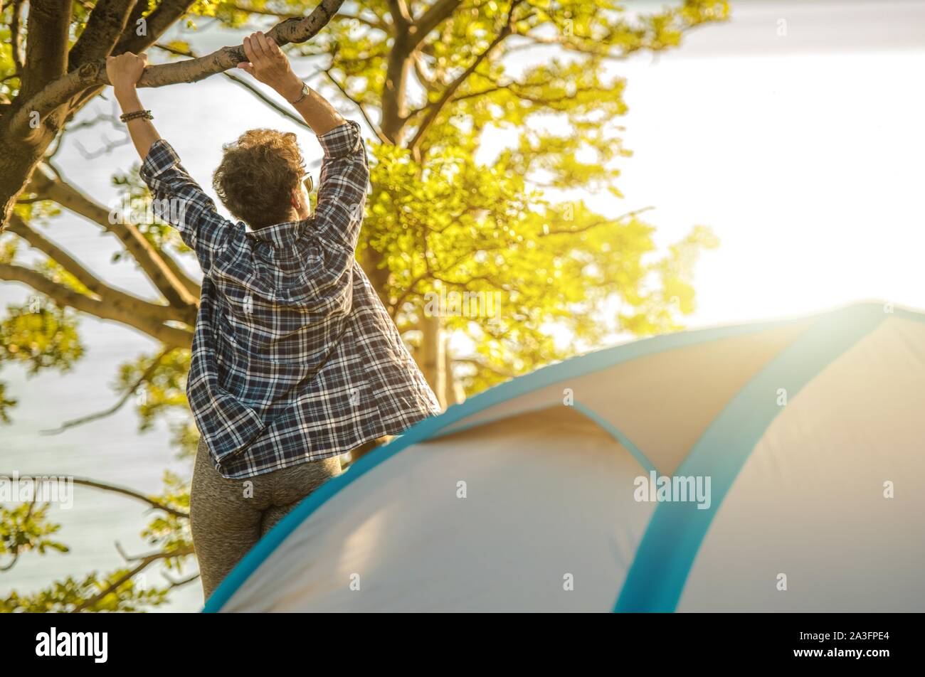 Caucasian Senior Woman Full of Life. Active Outdoor Living Lifestyle. Summer Vacation Tent Camping. Stock Photo